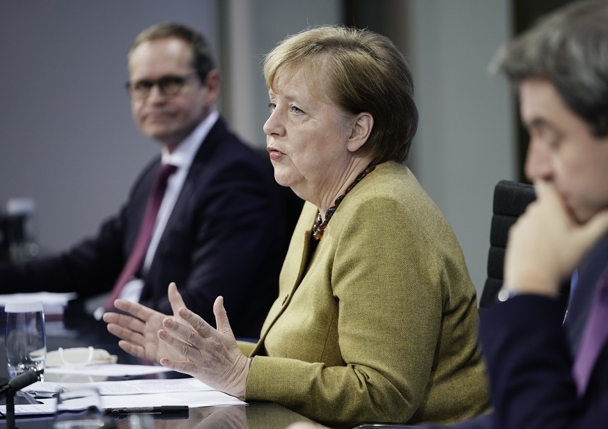 Germany's Chancellor Angela Merkel joins Markus Soeder (CSU), right, Prime Minister of Bavaria and CSU Chairman, and Michael Mueller (SPD), Governing Mayor of Berlin in a press conference following th ...