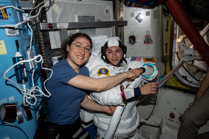 Christina Koch (l.) und Jessica Meir in einem Raumschiff.