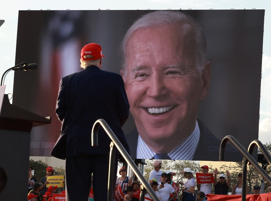 MIAMI, FLORIDA - NOVEMBER 06: Former U.S. President Donald Trump watches a video of President Joe Biden playing during a rally for Sen. Marco Rubio (R-FL) at the Miami-Dade Country Fair and Exposition ...