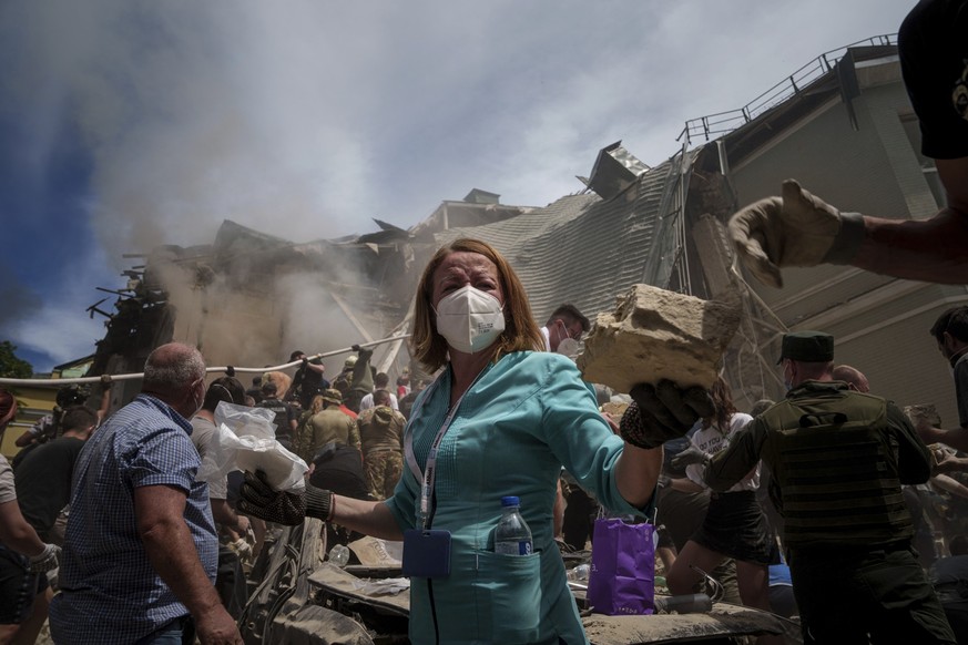 08.07.2024, Ukraine, Kiew: Rettungskräfte stehen vor dem Okhmatdyt-Kinderkrankenhaus, das von russischen Raketen getroffen wurde. Russische Raketen haben mehrere Menschen getötet und ein Kinderkranken ...