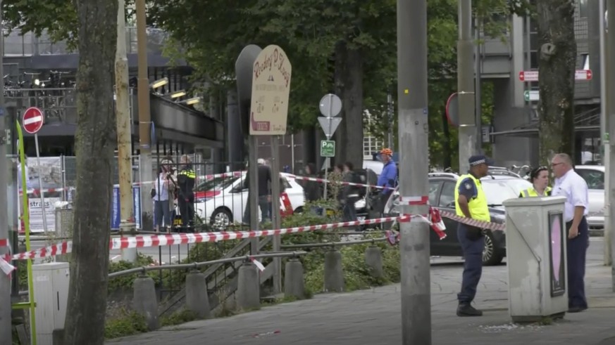 In this image made from video, Dutch police officers stand near the scene of a stabbing attack near the central daily station in Amsterdam, the Netherlands, Friday Aug. 31, 2018. Police the Dutch capi ...