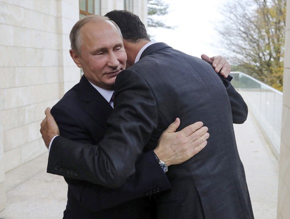 FILE - Russian President Vladimir Putin, left, embraces Syrian President Bashar Assad in the Bocharov Ruchei residence in the Black Sea resort of Sochi, Russia, Nov. 20, 2017. Political observers say  ...