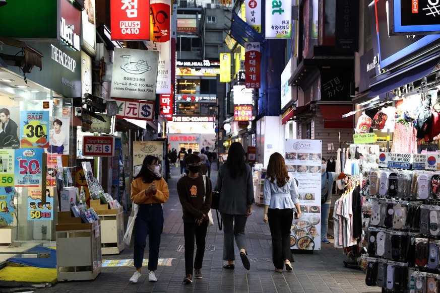 SEOUL, SOUTH KOREA - MAY 06: People walk along the street in face masks on May 06, 2020 in Seoul, South Korea. South Korea returned largely to normal as citizens return to their daily routines under e ...