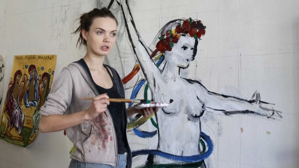 Oksana Shachko, activist of women's rights group Femen, speaks while painting a wall of her room in Kiev, Ukraine February 21, 2012. Picture taken February 21, 2012. REUTERS/Gleb Garanich
