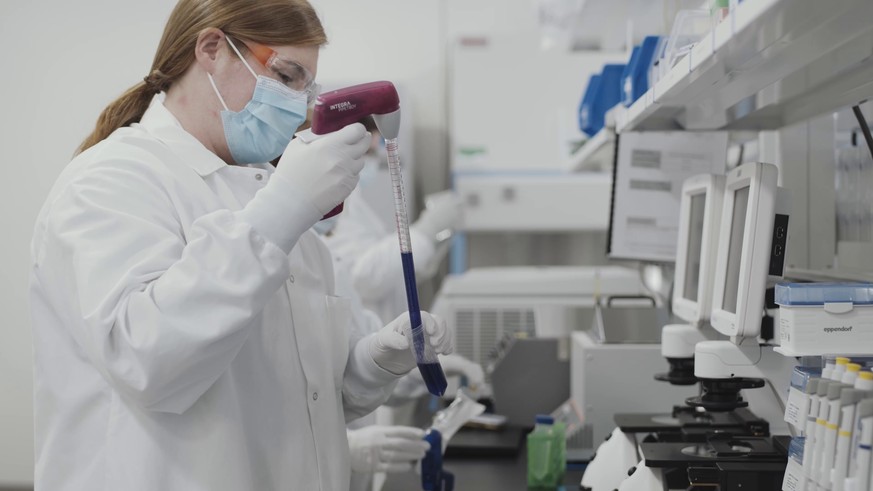 Das Videostandbild zeigt eine Mitarbeiterin des US-Pharmakonzerns Moderna als sie an der Herstellung eines Corona-Impfstoffs arbeitet.