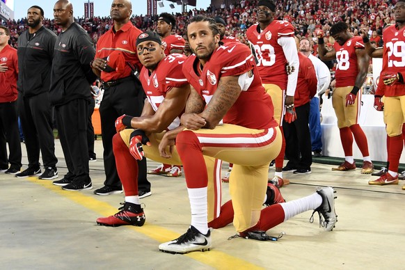 SANTA CLARA, CA - SEPTEMBER 12: Colin Kaepernick #7 and Eric Reid #35 of the San Francisco 49ers kneel in protest during the national anthem prior to playing the Los Angeles Rams in their NFL game at  ...