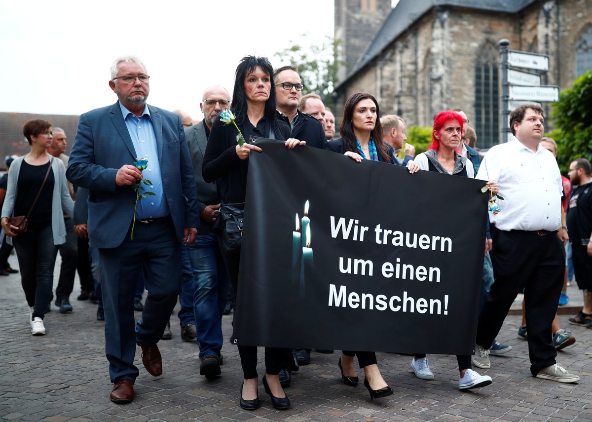 People hold a banner reading: "We mourn for a human" as they march to the crime scene during a gathering organised by Germany's anti-immigration party Alternative for Germany (AfD), aft ...