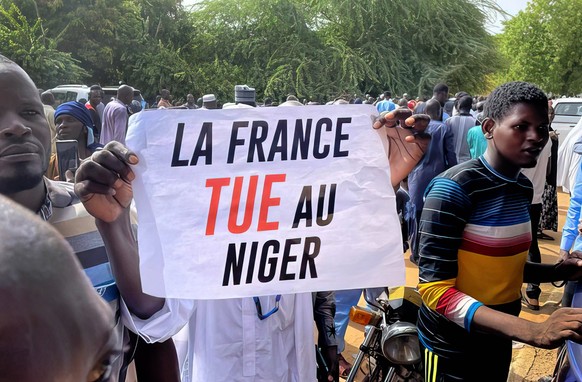 Niger, Proteste vor der Botschaft von Frankreich in Niamey Supporters Of Coup Denounce France - Niamey Supporter of Niger s junta hold a sign says France kills in Niger Numerous slogans against France ...
