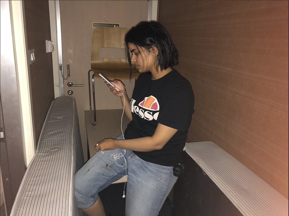 In this Monday, Jan. 7, 2019, photo released by Rahaf Mohammed Alqunun/Human Rights Watch, Rahaf Mohammed Alqunan views her mobile phone as she sits barricaded in a hotel room at an international airp ...