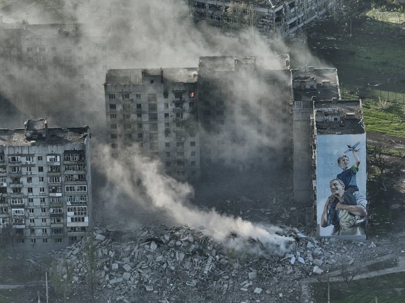 dpatopbilder - 26.04.2023, Ukraine, Bachmut: Rauch steigt von einem Gebäude in Bachmut in der Region Donezk auf. Foto: Libkos/AP/dpa +++ dpa-Bildfunk +++