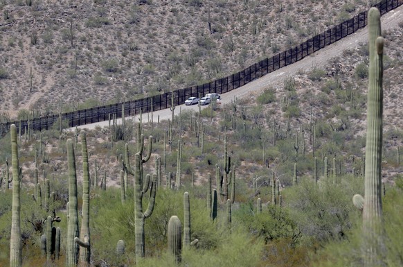 U.S. Customs and Patrol Patrol agents sit along a section of the international border wall that runs through Organ Pipe National Monument, Thursday, Aug. 22, 2019 in Lukeville, Ariz. Construction on a ...