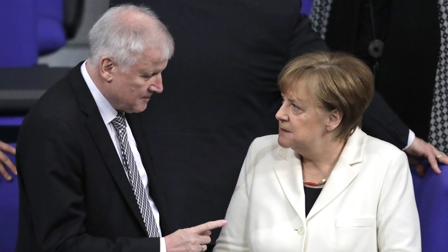 FILE - In this March 14, 2018 file photo German Interior Minister Horst Seehofer, left, talks to German Chancellor Angela Merkel in the German parliament in Berlin. Germany’s new interior minister is  ...