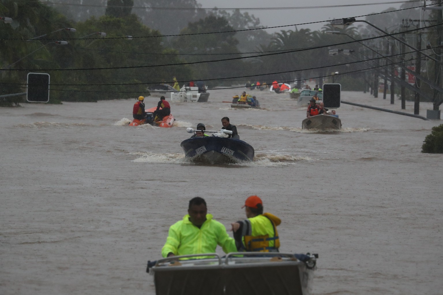 28.02.2022, Australien, Lismore: Menschen fahren in Booten im Hochwasser einer