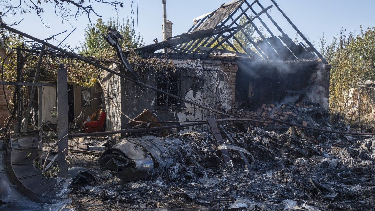 ARCHIV - 05.10.2024, Ukraine, Kostjantyniwka: Ein beschädigtes Haus ist im Hintergrund von Fragmenten eines abgeschossenen russischen Militärflugzeugs am Stadtrand von Kostjantyniwka, einer Stadt nahe ...