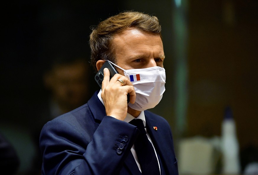 FILE - In this Monday, July 20, 2020 file photo, French President Emmanuel Macron speaks on his mobile phone during a round table meeting at an EU summit in Brussels. French newspaper Le Monde is repo ...