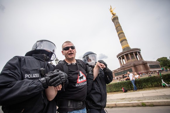 30.08.2020, Berlin: Ein Mann wird bei einem Protest gegen die Corona-Maßnahmen vor der Siegessäule von Polizisten abgeführt. Foto: Christoph Soeder/dpa +++ dpa-Bildfunk +++