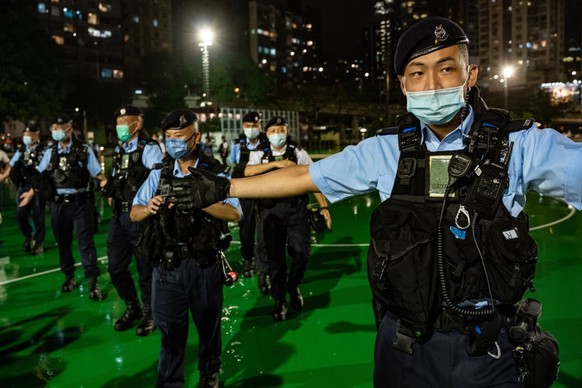 HONG KONG, CHINA - JUNE 03: Police officers setup a cordon as they disperse public out of the Victoria Park ahead of the 33rd anniversary of Tiananmen Square incident on June 03, 2022 in Hong Kong, Ch ...