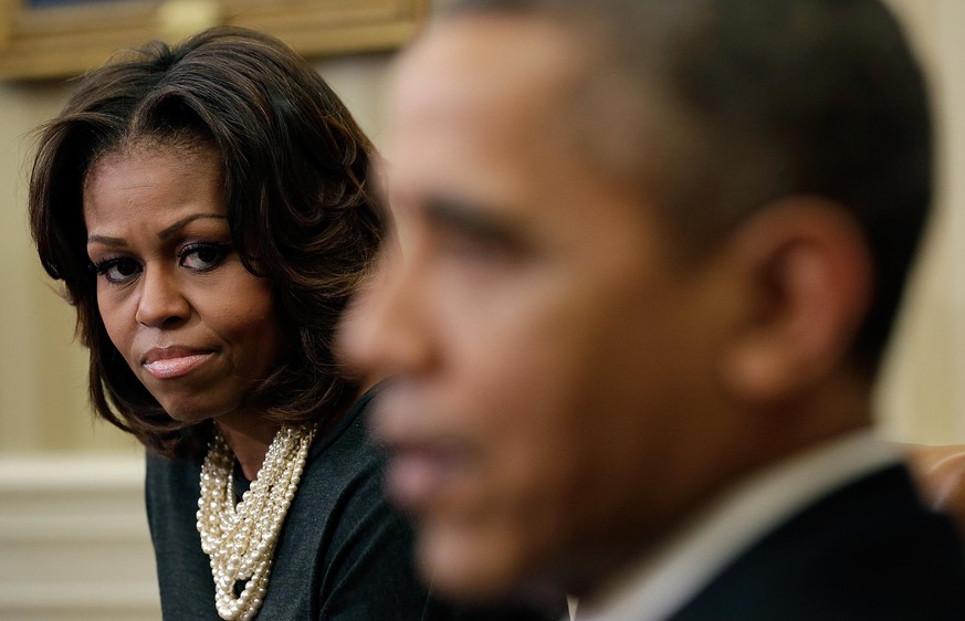 WASHINGTON, DC - DECEMBER 18: U.S. President Barack Obama makes remarks as first lady Michelle Obama looks on following a meeting with a group of mothers in the Oval Office of the White House December ...