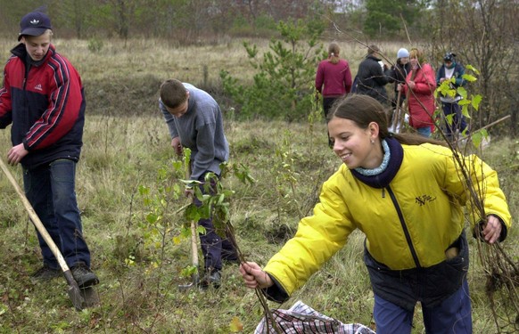 Schüler und Lehrer von weiterführenden Schulen in der Region Stary Oskol im Gebiet Belgorod in Russland pflanzen Setzlinge von Laubbäumen auf einem brach liegenden Gelände in ihrer Region. Die Aktion  ...