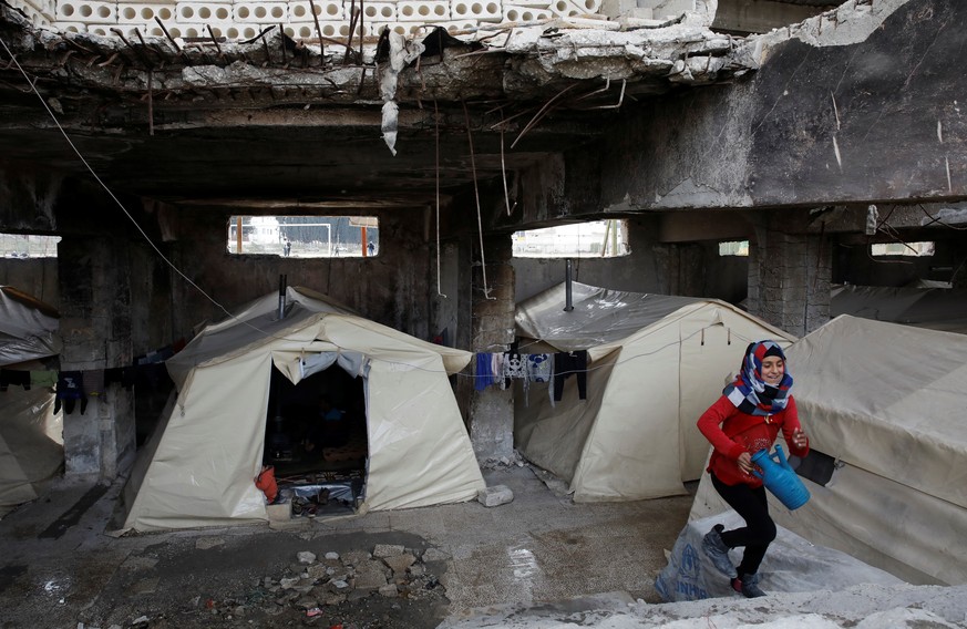 An internally displaced Syrian girl steps up the stairs in an IDP camp located in Idlib, Syria February 27, 2020. REUTERS/Umit Bektas