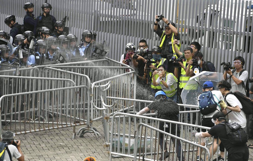 Hong Kong demonstration against extradition bill Police fire tear gas spray on protestors near Hong Kong s legislature building on June 12, 2019, as tens of thousands of people occupy major roads ther ...