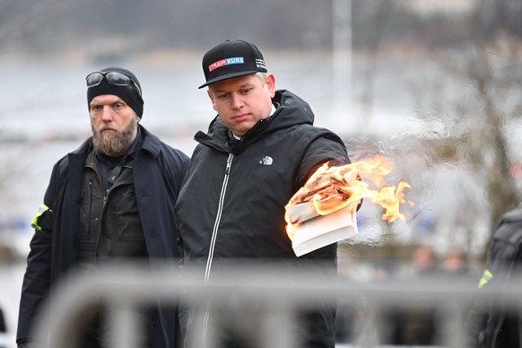 STOCKHOLM 20230121 Den högerextreme politikern Rasmus Paludan bränner ett exemplar av muslimernas heliga bok, koranen, da han haller en allmän sammankomst i närheten av Turkiets ambassad pa lördagen.  ...