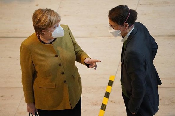 BERLIN, GERMANY - MARCH 04: German Chancellor Angela Merkel speaks with Karl Lauterbach, Bundestag MP of the German Social Democrats (SPD) and epidemiologist, after she cast her ballot following debat ...