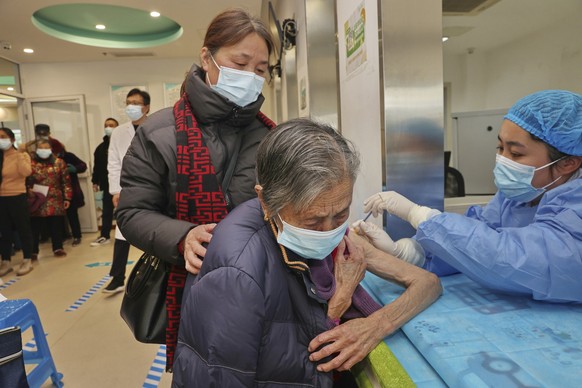 23.12.2022, China, Nantong: Eine Krankenschwester verabreicht auf dem mam 23.12.2022 zur Verfügung gestellten Foto einer alten Frau in einem kommunalen Gesundheitszentrum in Nantong in der ostchinesis ...