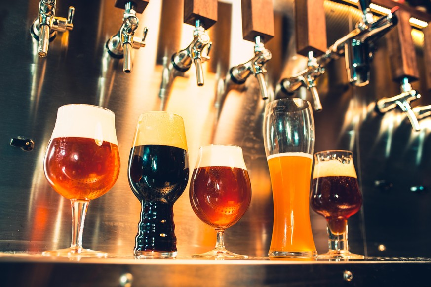 The beer taps in a pub. nobody. Selective focus. Alcohol concept. Vintage style. Beer craft. Bar table. Steel taps. Shiny taps. Glass of beer