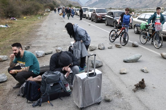 REPUBLIC OF NORTH OSSETIA-ALANIA, RUSSIA - SEPTEMBER 28, 2022: People are seen by a queue of vehicles on the road for the Verkhny Lars checkpoint on the Russian-Georgian border. According to the Georg ...