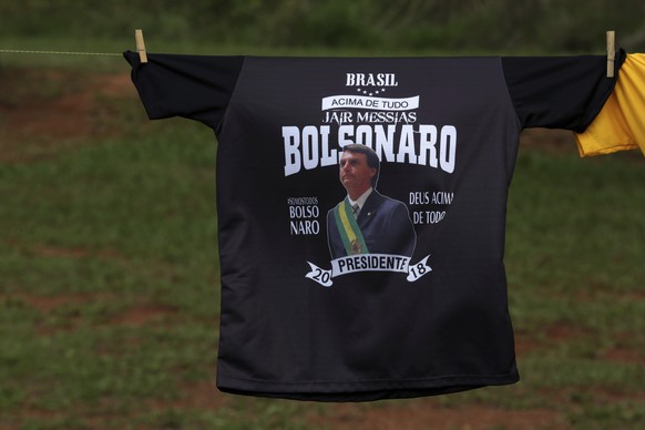 Three days before the second round of the election, supporters sell T-shirts showing presidential frontrunner Jair Bolsonaro wearing the presidential sash, in Brasilia, Brazil, Friday, Oct. 26, 2018. ...
