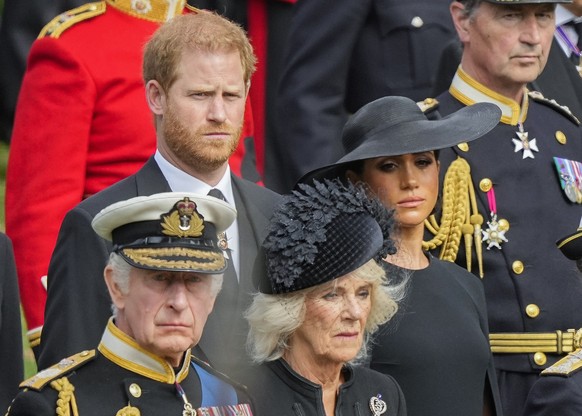 FILE - Britain's King Charles III, from bottom left, Camilla, the Queen Consort, Meghan, Duchess of Sussex and Prince Harry watch as the coffin of Queen Elizabeth II is placed into the hearse followin ...