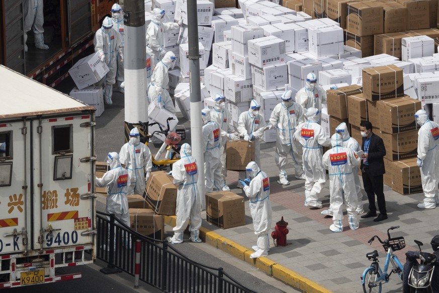 SHANGHAI, CHINA - APRIL 10, 2022 - Street volunteers and workers unload medical supplies such as masks and traditional Chinese medicine, on April 10, 2022 in Shanghai, China. Shanghai is under lockdow ...