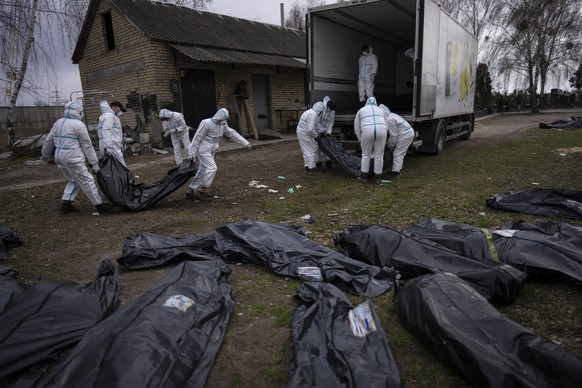 Freiwillige laden die Leichen der in Butscha getöteten Zivilist:innen auf einen Lastwagen.