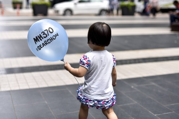 March 4, 2017 - Kuala Lumpur, Malaysia - A little girl holds a balloon with the name of the missing Malaysia Airlines ill-fated flight MH370 are seen displayed during a memorial event in Kuala Lumpur, ...