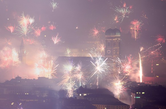 01.01.2019, Bayern, München: Feuerwerksraketen explodieren in der Silvesternacht über der Frauenkirche und der Innenstadt. Foto: Matthias Balk/dpa