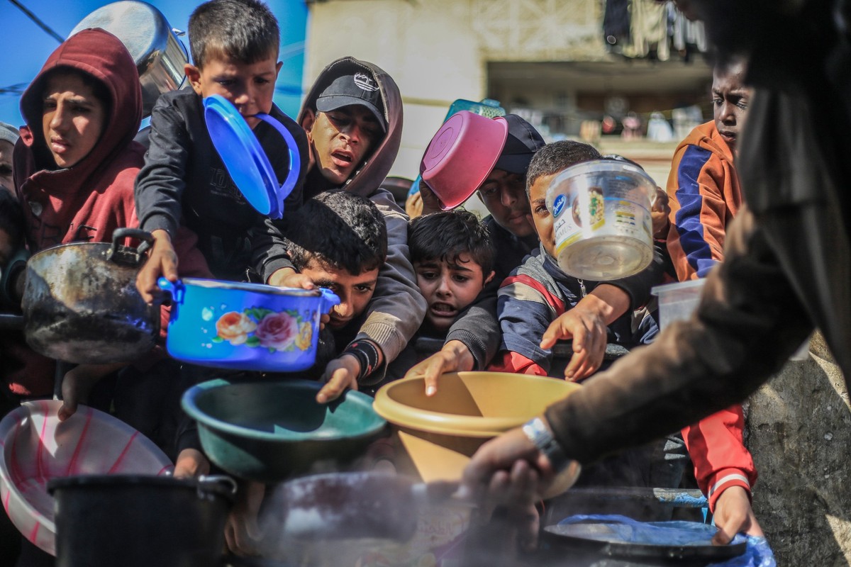 ARCHIV - 31.12.2023, Palästinensische Gebiete, Rafah: Palästinensische Kinder erhalten in einer Wohltätigkeitsküche zubereitete Lebensmittel. (zu dpa: «Bericht: Netanjahu ordnet mehr Hilfslieferungen ...