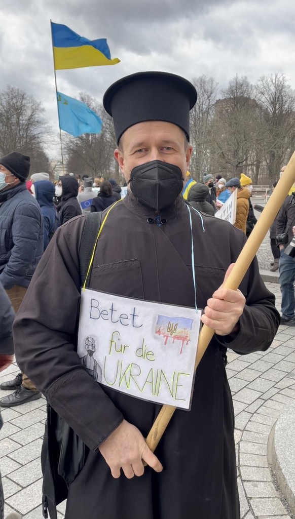 "Betet für die Ukraine" steht auf dem Schild des ukrainischen Priesters Artem Bondarenko.