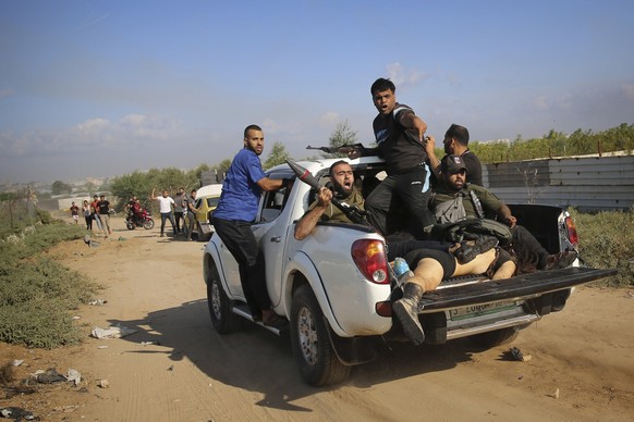 Palestinian militants drive back to the Gaza Strip with the body of Shani Louk, a German-Israeli dual citizen, during their cross-border attack on Israel, Saturday, Oct. 7, 2023. (AP Photo/Ali Mahmud)