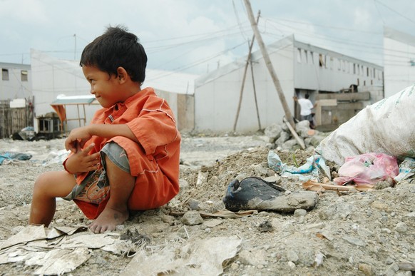 A child smiles at his friends in Baseco, a slum area near the North Pie, Manila, Philippines August 30,2006