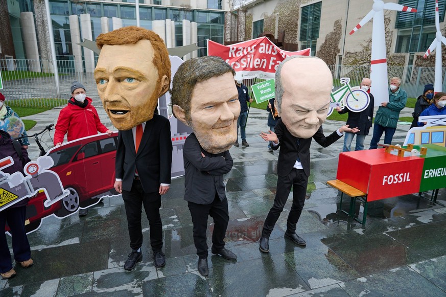 Vor dem Kanzleramt in Berlin legten Kundgebungsteilnehmer mit Grossmasken von Bundeskanzler Olaf Scholz, Bundesfinanzminister Christian Lindner und Bundeswirtschaftsminister Robert Habeck, einen Schal ...