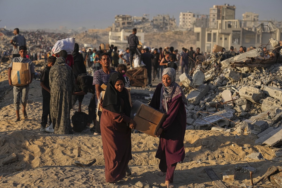 16.06.2025, Palästinensische Gebiete, Gaza-Stadt: Palästinenser tragen Säcke und Kisten mit Lebensmitteln und humanitärer Hilfe, die in einem Konvoi des Welternährungsprogramms gebracht wurden. Foto: ...