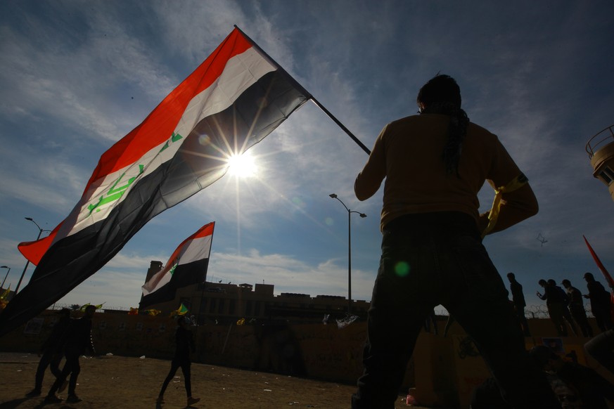 Ein Demonstrant mit einer irakischen Fahne an Neujahr vor der US-Botschaft in Bagdad.