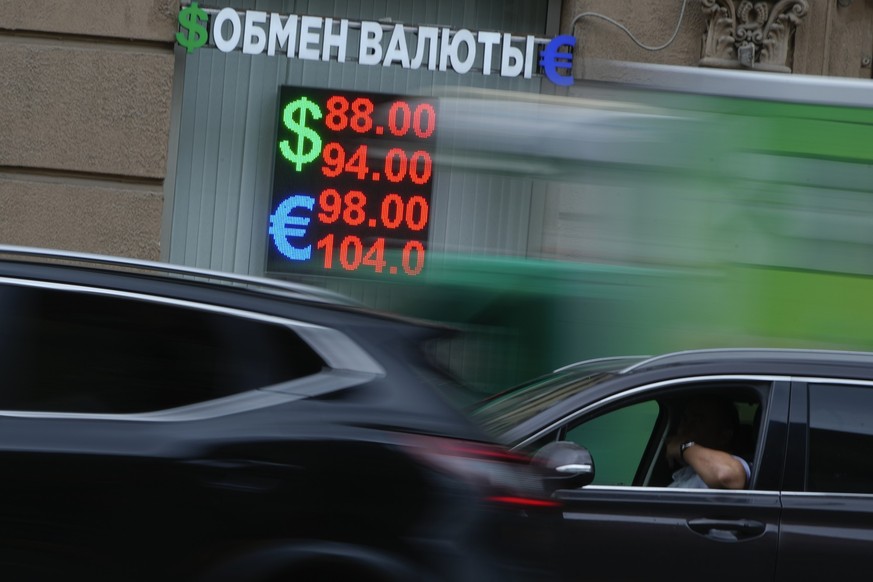 An electronic board with exchange rates at a currency exchange office is seen through traffic in Moscow, Russia, Thursday, June 13, 2024. The U.S sanctioned the Moscow Exchange Wednesday, prompting Ru ...