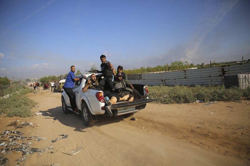 07.10.2023, Palästinensische Gebiete, -: Militante Palästinenser fahren mit einem Pickup, auf dem möglicherweise eine deutsch-israelische Frau zu sehen ist, in den Gazastreifen zurück. Die islamistisc ...