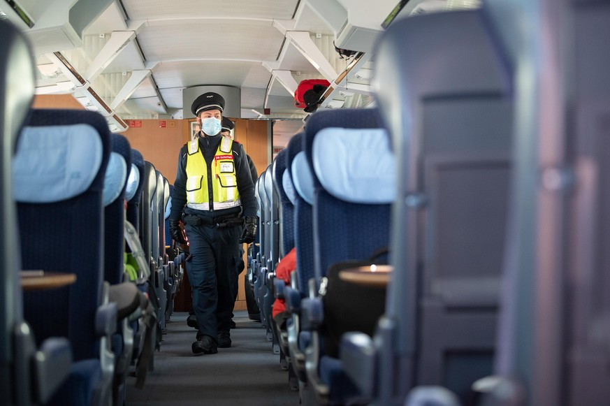 Ein Mitarbeiter der DB-Sicherheit kontrolliert am Stuttgarter Hauptbahnhof die Maskenpflicht in einem ICE der Deutschen Bahn.