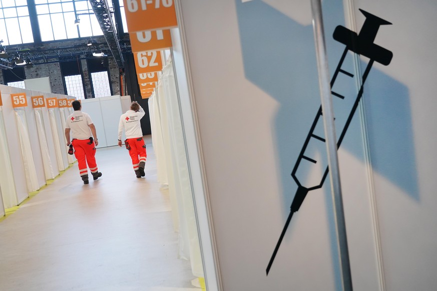 BERLIN, GERMANY - DECEMBER 21: Workers from the German Red Cross (DRK) walk among inoculation cabins at the completed Covid-19 vaccination center at the Arena Berlin events venue on December 21, 2020  ...