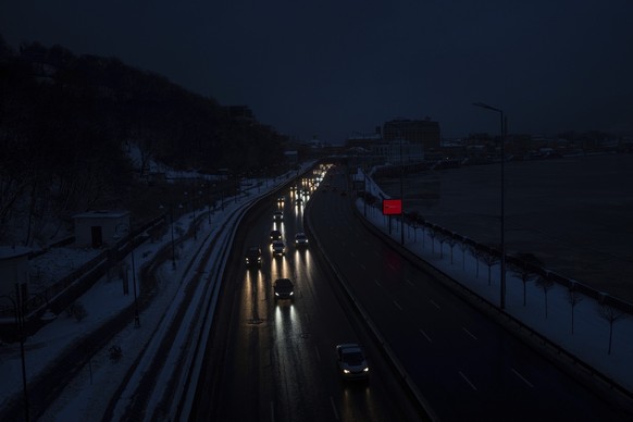 15.12.2022, Ukraine, Kiew: Autos fahren auf der Autobahn w�hrend eines Stromausfalls in Kiew. Foto: Evgeniy Maloletka/AP/dpa +++ dpa-Bildfunk +++
