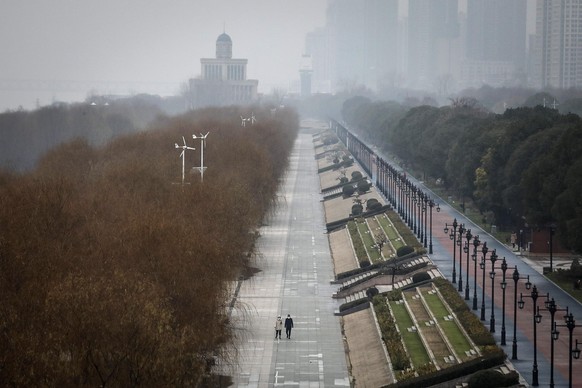 WUHAN, CHINA - JANUARY 27: (CHINA-OUT) Two residents walk in an empty Jiangtan park on January 27, 2020 in Wuhan, China. As the death toll from the coronavirus reaches 80 in China with over 2700 confi ...