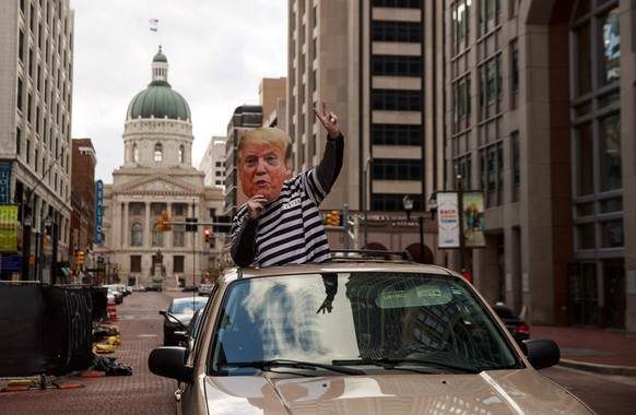 November 1, 2020, Indianapolis, Indiana, United States: Protester dressed as Trump in a prison uniform drive past the Soldiers and Sailors Monument during a Trump caravan parade two days before the 20 ...